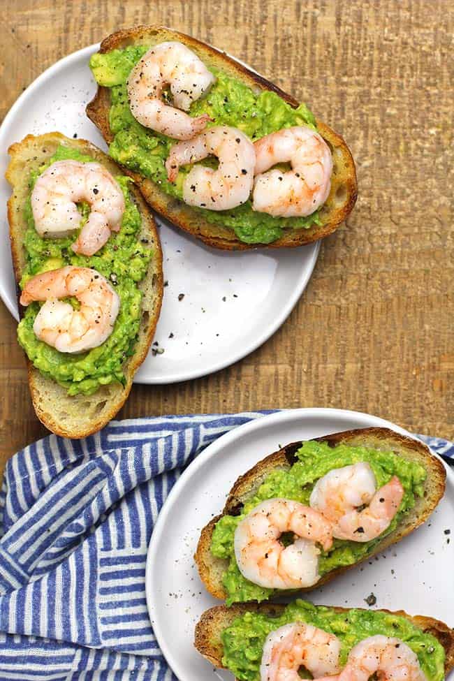 Two plates of shrimp avocado crostini appetizers.