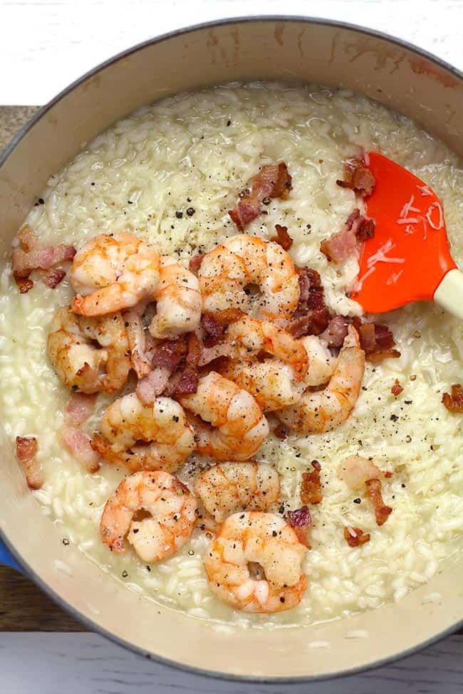 Overhead shot of a stock pot of creamy shrimp risotto with bacon.