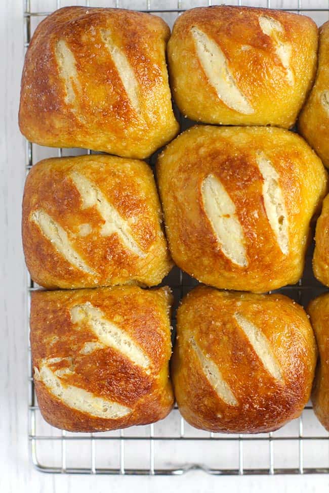 Closeup of some soft pretzel rolls on a cooling rack.