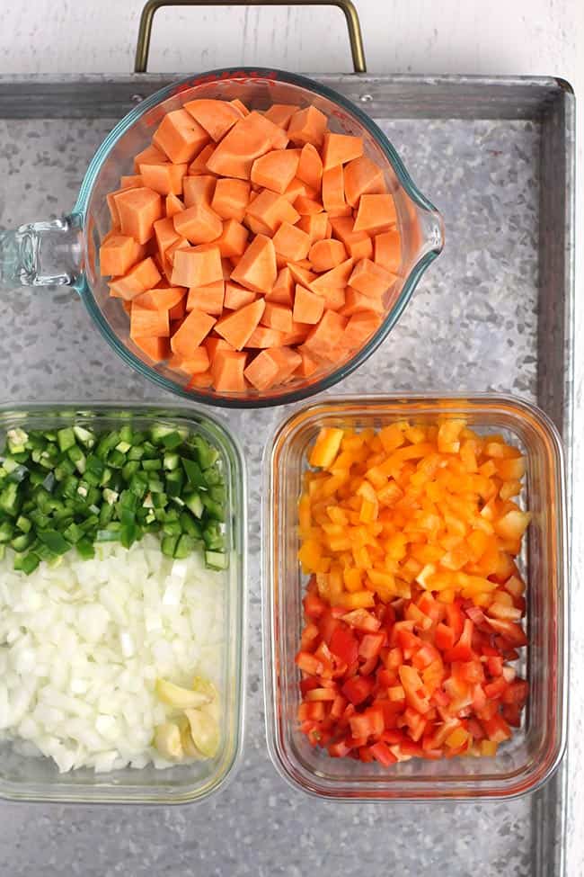 A gray tray with all the chopped veggies in dishes, ready to use in the chili.