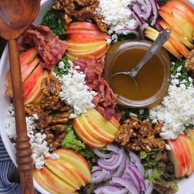 Overhead shot of a large loaded fall harvest salad with balsamic dressing.