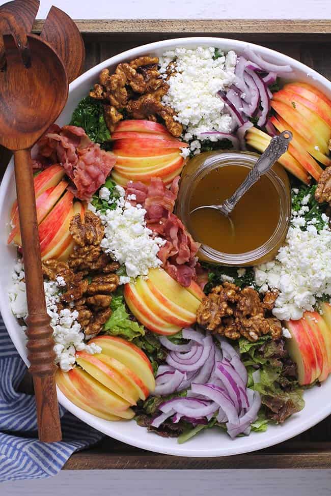 Overhead shot of a large loaded fall harvest salad with balsamic dressing.