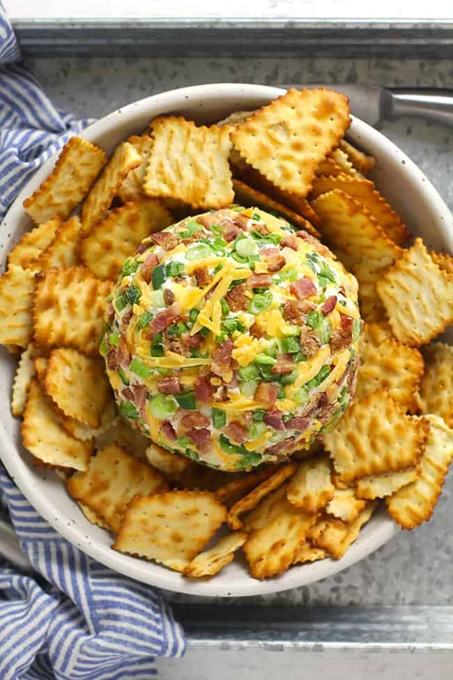 Overhead view of a jalapeño popper cheese ball with crackers.