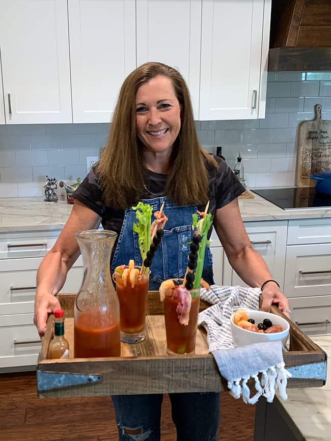 Me, holding a wooden tray of Bloody Marys and a partial carafe.