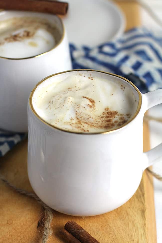 Side shot of a mug of homemade pumpkin latte with cinnamon and a milk froth.