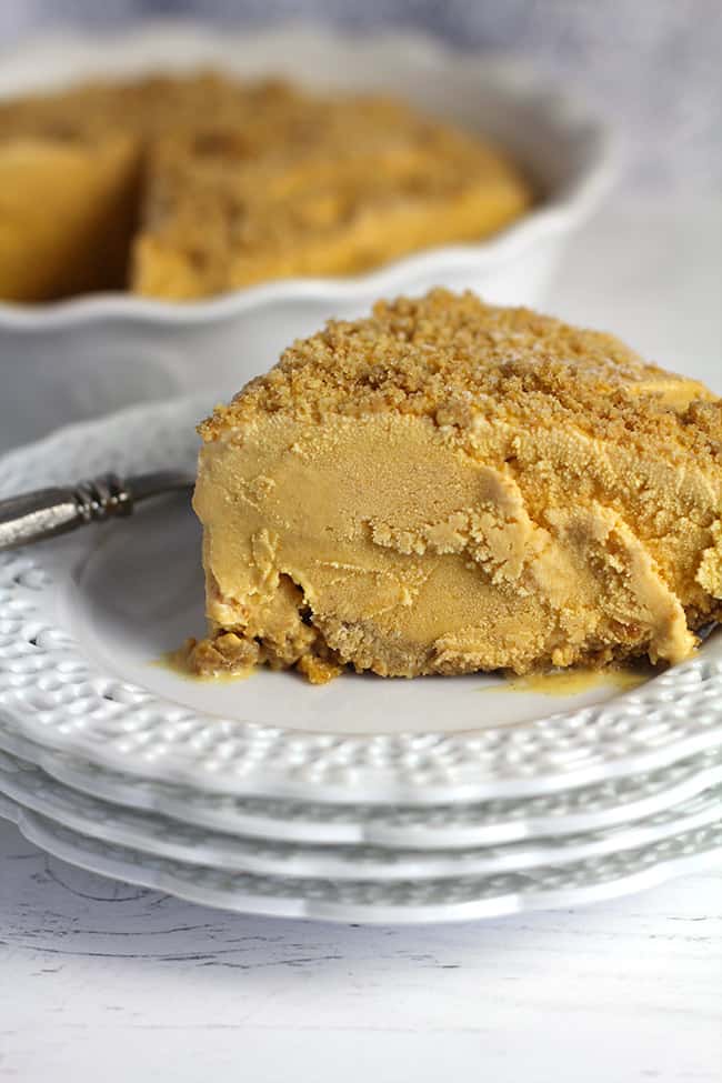 A closeup on a slice of pumpkin ice cream dessert, on a white serving plate.
