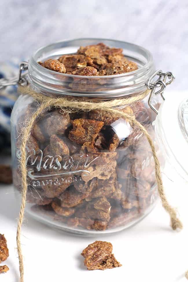 Side shot of a large mason jar of candied pecans.