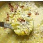 A pot of corn chowder with a ladle of soup pulling up.