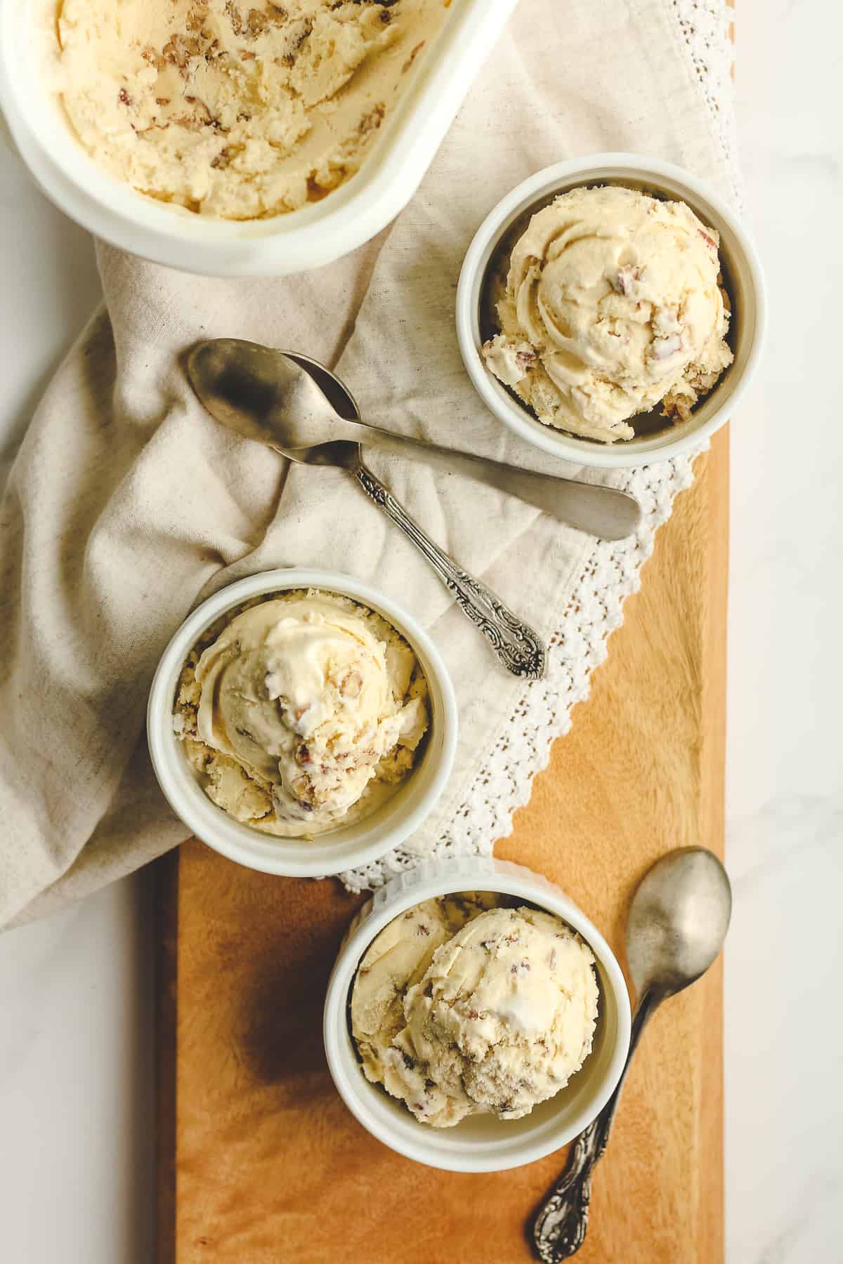 Overhead shot of three small bowls of butter pecan with spoons.