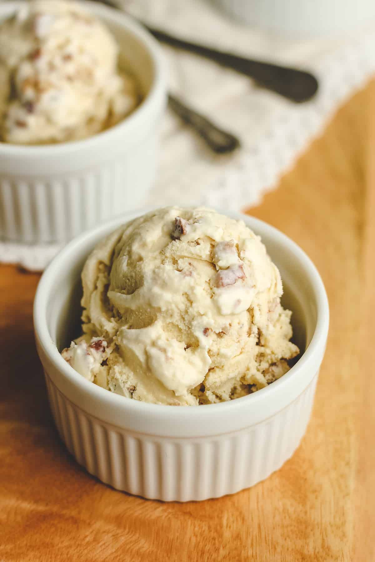 Side shot of a small bowl of butter pecan ice cream.