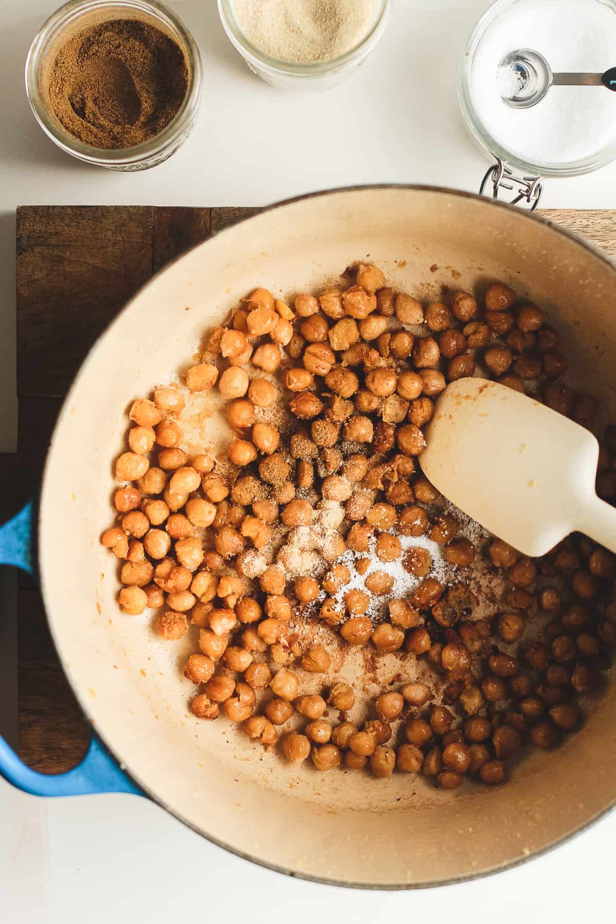 A dutch oven with the crispy chickpeas right after cooking, with seasonings on top.