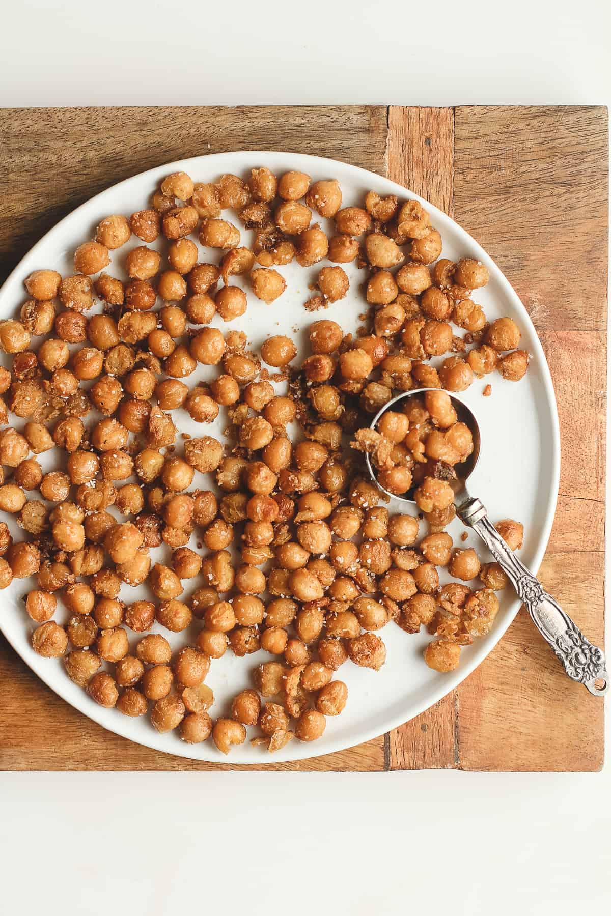 A plate of crispy chickpeas, with a tablespoon.
