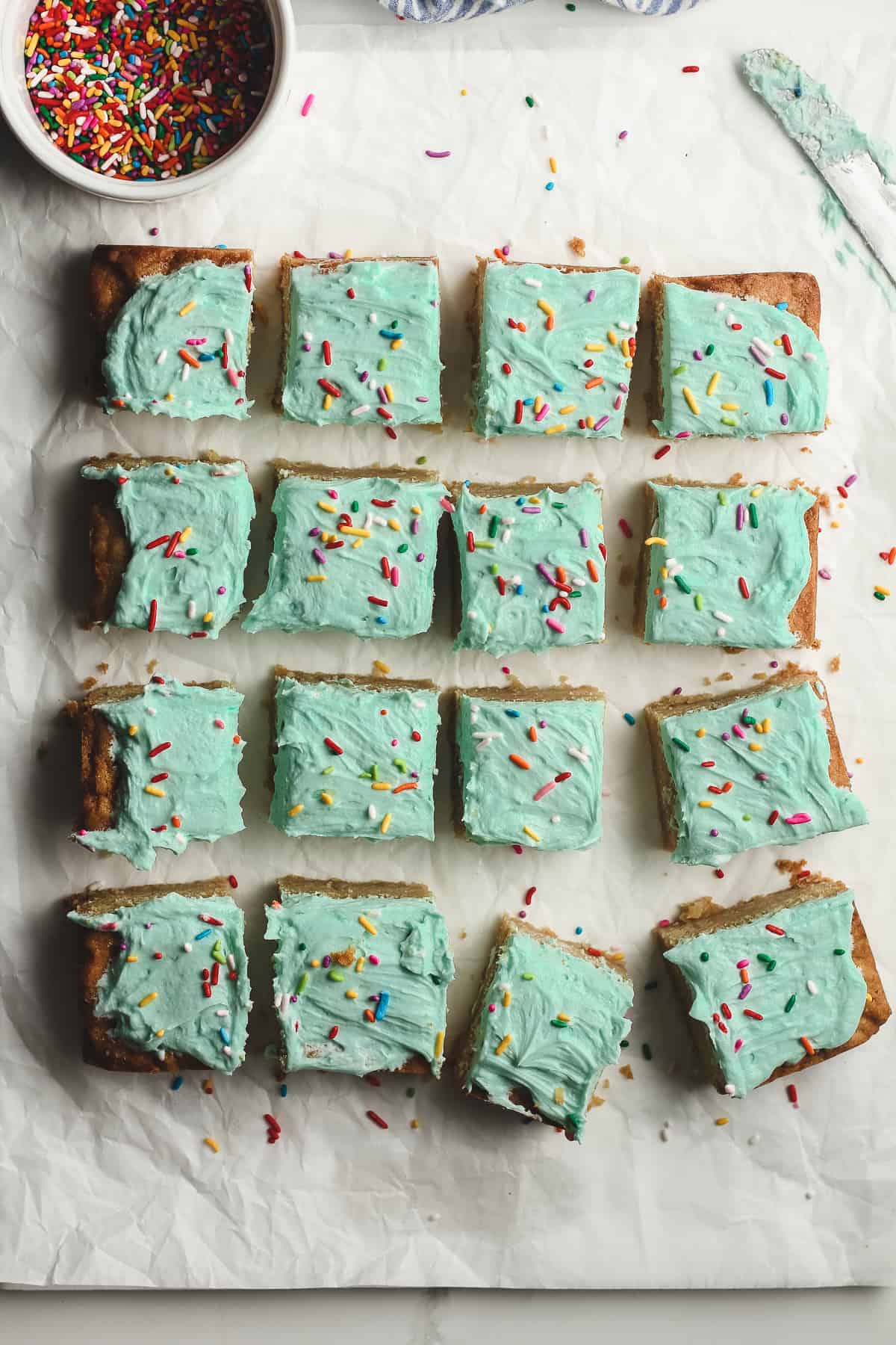 16 frosted sugar cookie bars with sprinkles.