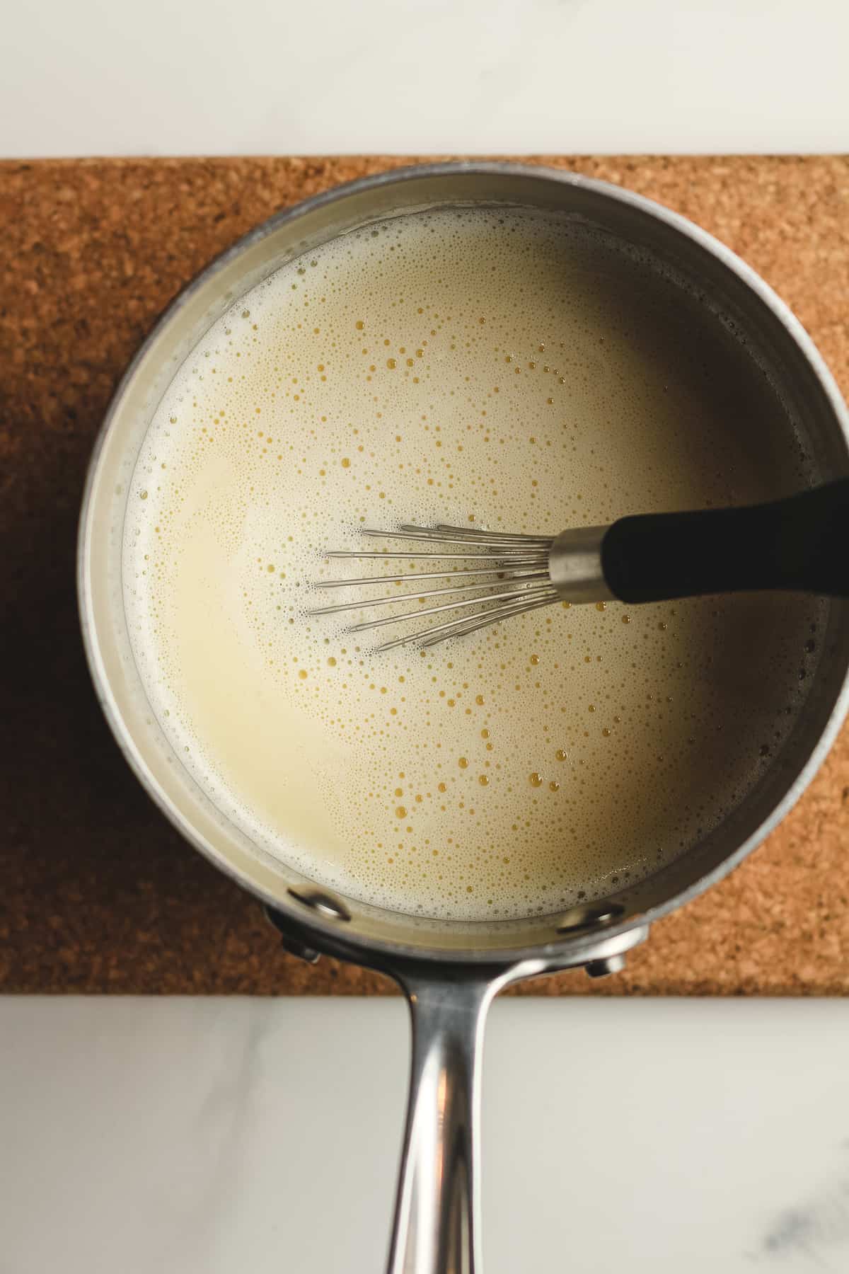 Overhead shot of a saucepan of the tempered egg mix.