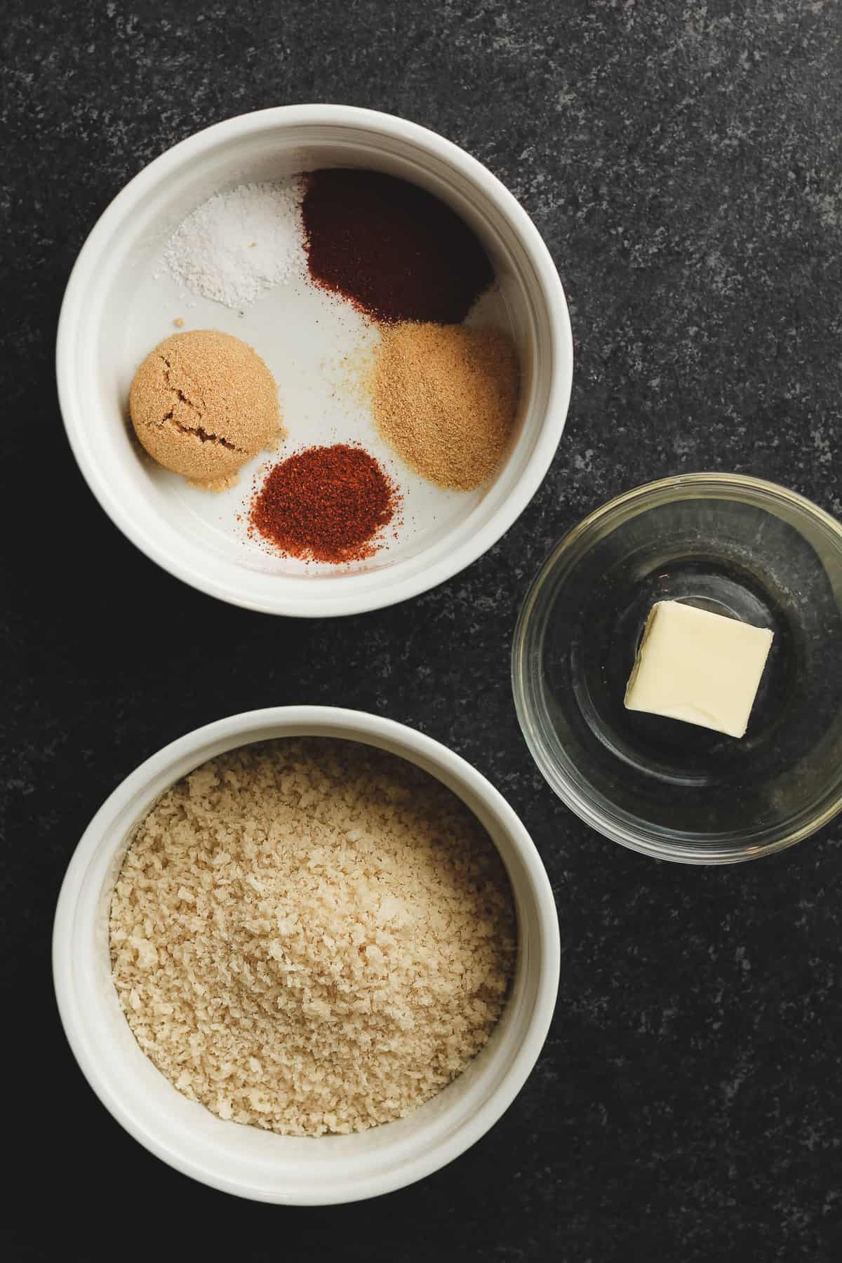 Separate bowls of seasoning, Panko crumbs, and butter.