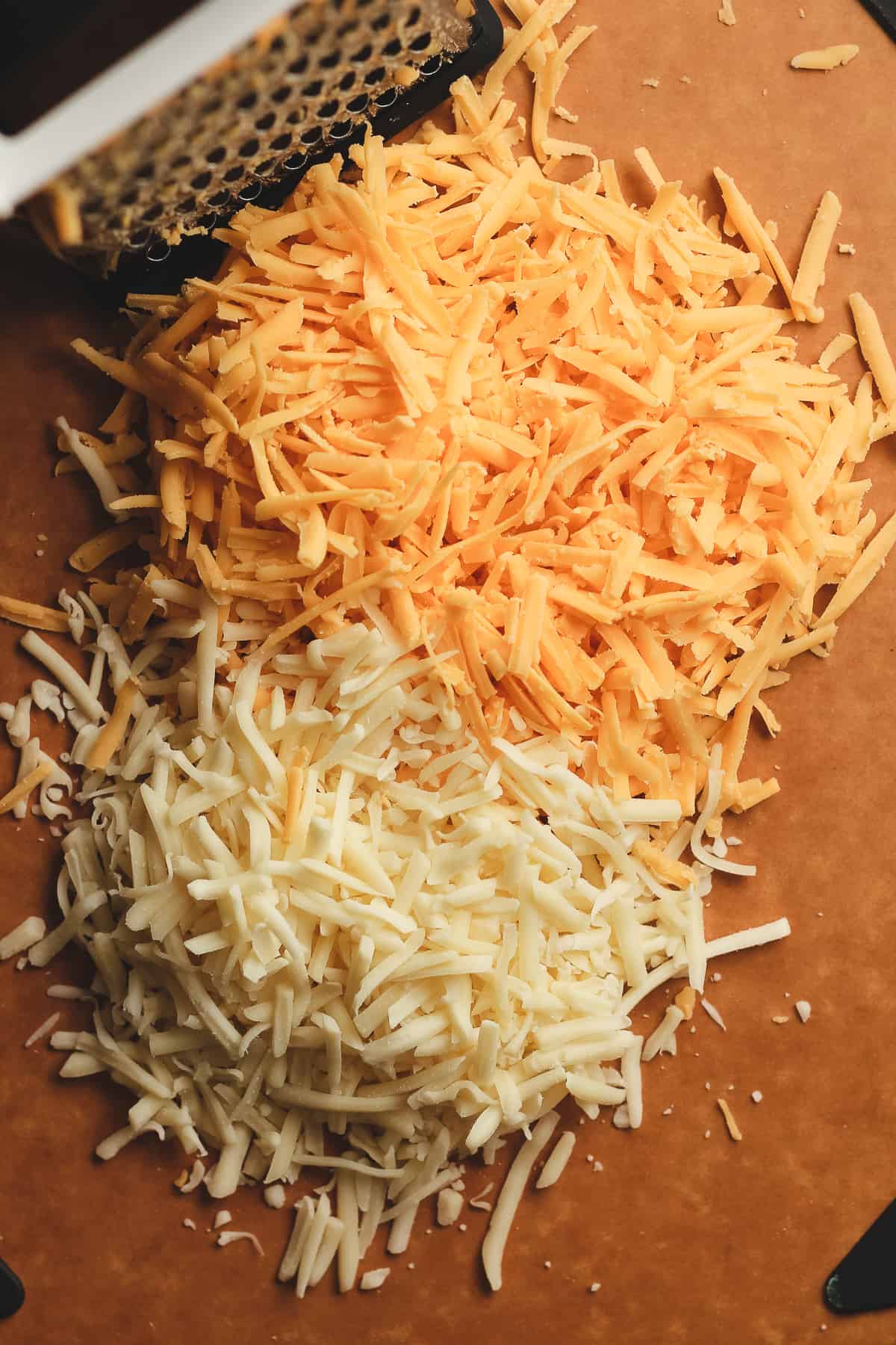 Shredded cheese on a cutting board.