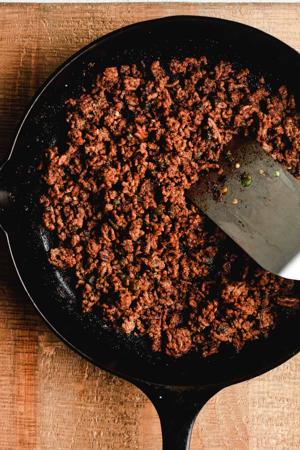 Cast iron skillet with cooked taco meat.
