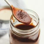 Side shot of a jar of barbecue sauce with a spoonful closeup.