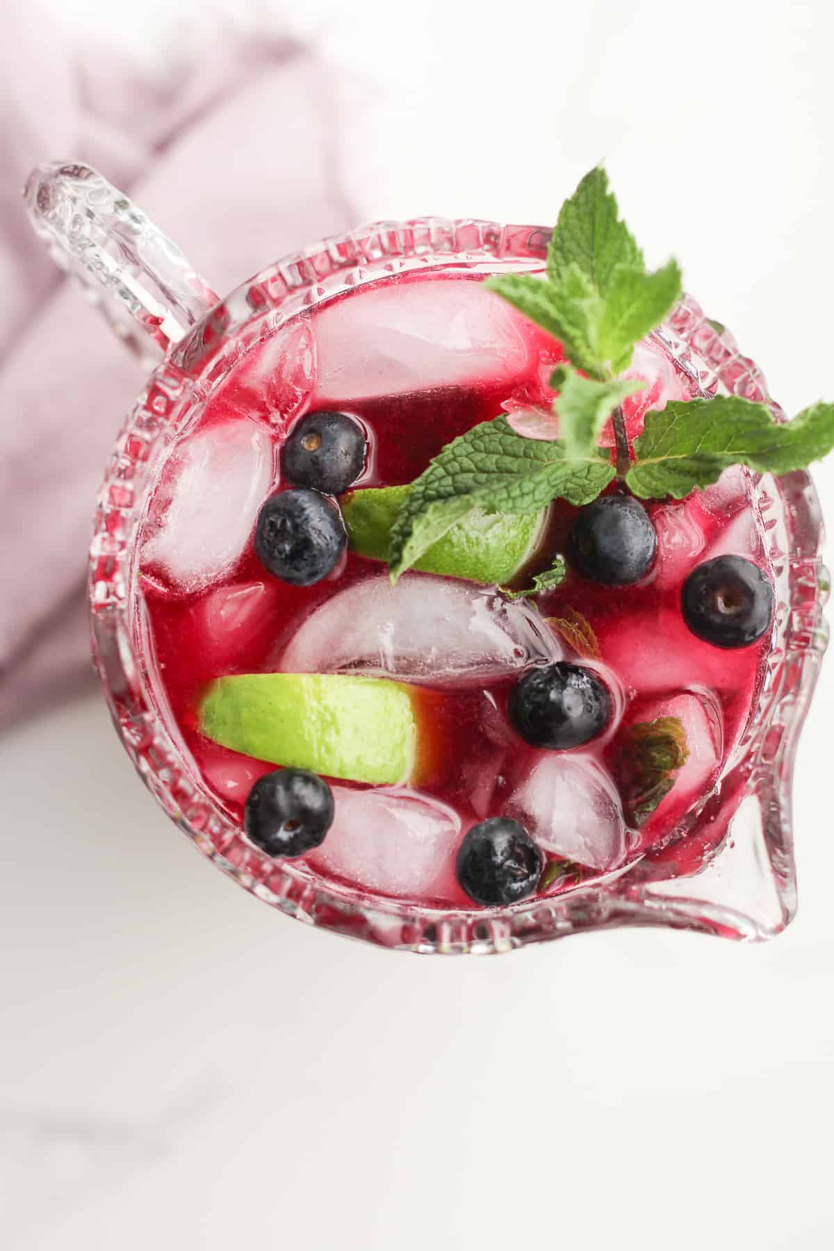 Overhead shot of a pitcher of blueberry mojitos.