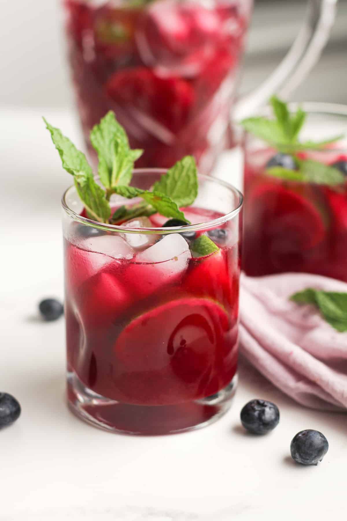 Glasses of blueberry mojitos with fresh mint and blueberries.