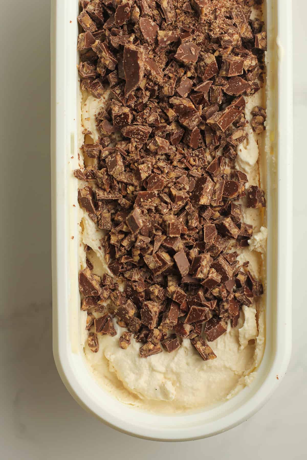 A container of coffee ice cream with the toffee candy on top.