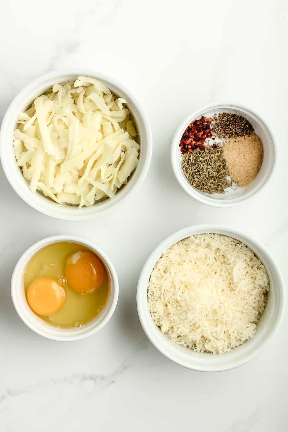 Four bowls of the cauliflower pizza crust ingredients.