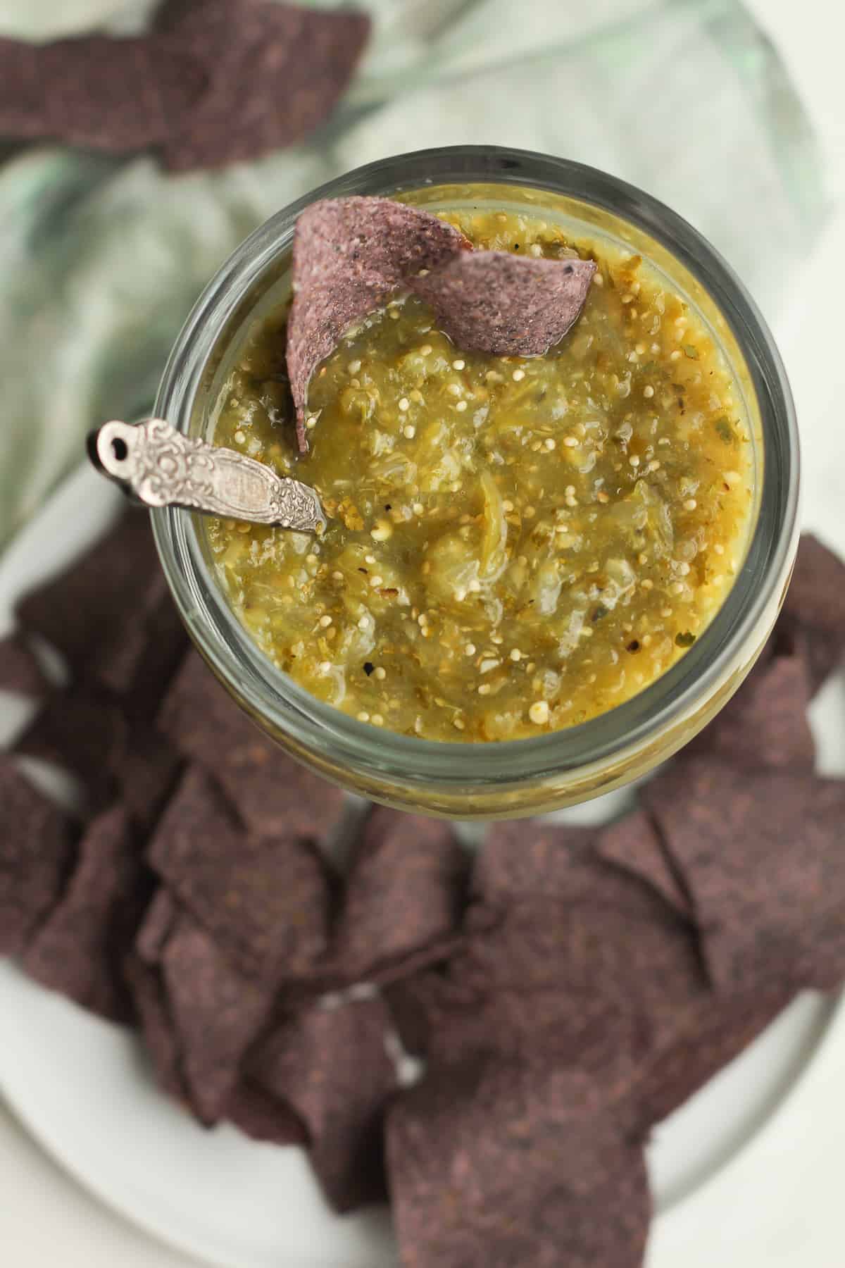 Closeup on a bowl of salsa verde, with chips.