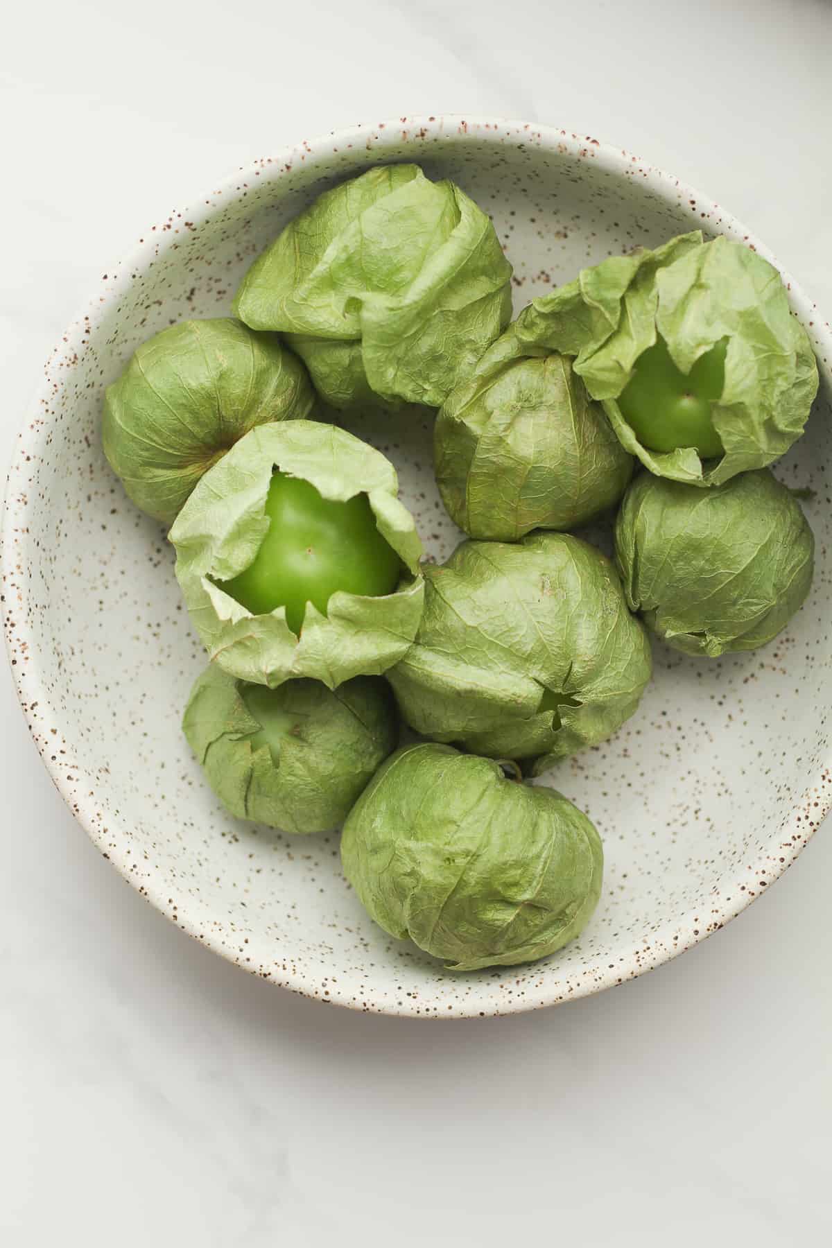 A bowl of tomatillos, in husks.