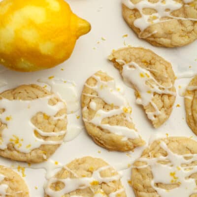 Several lemon sugar cookies with glaze, and one cookie in half.