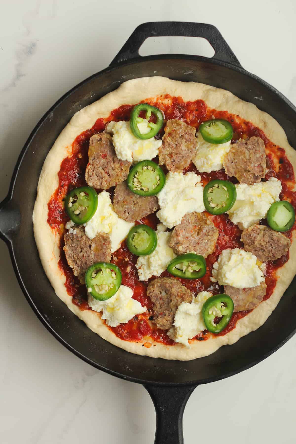 Unbaked pizza in skillet.