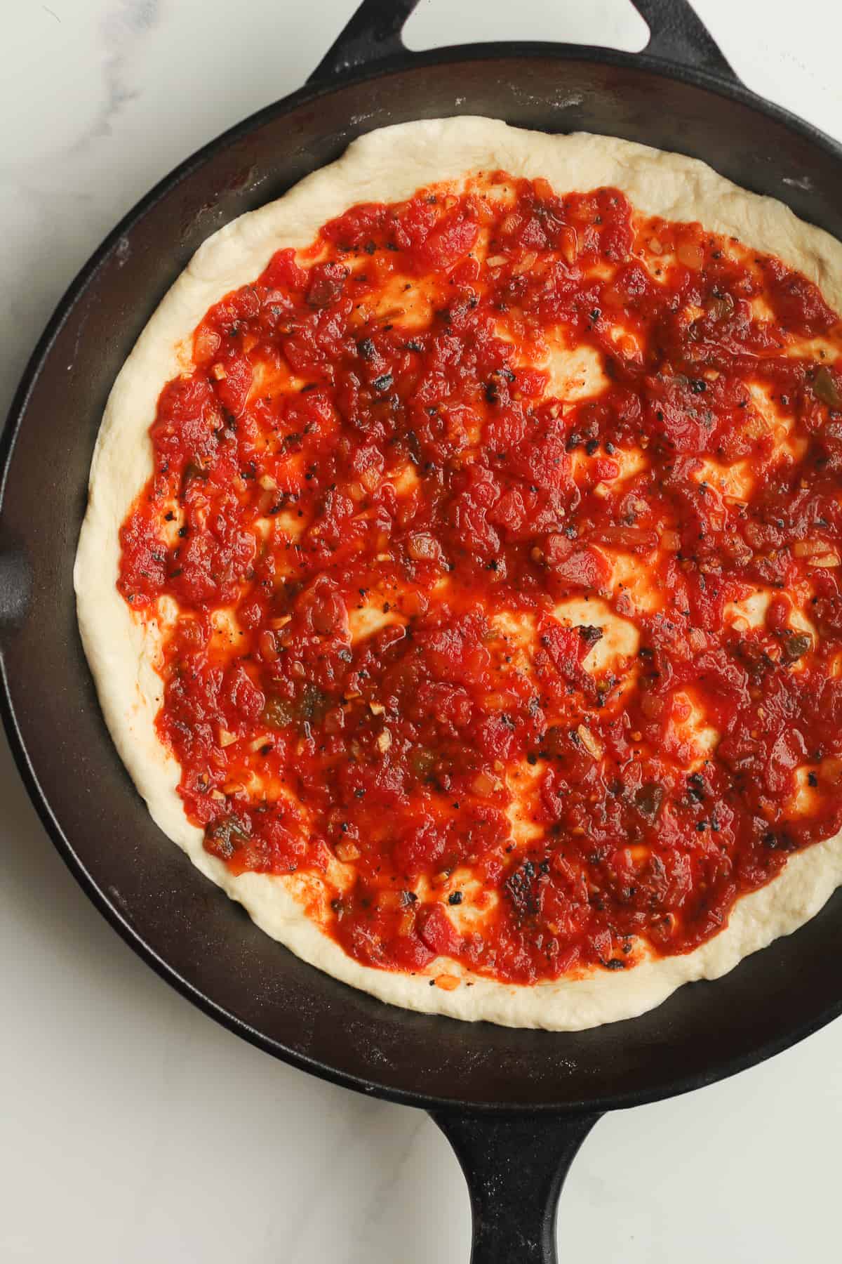 Homemade pizza sauce on the dough.