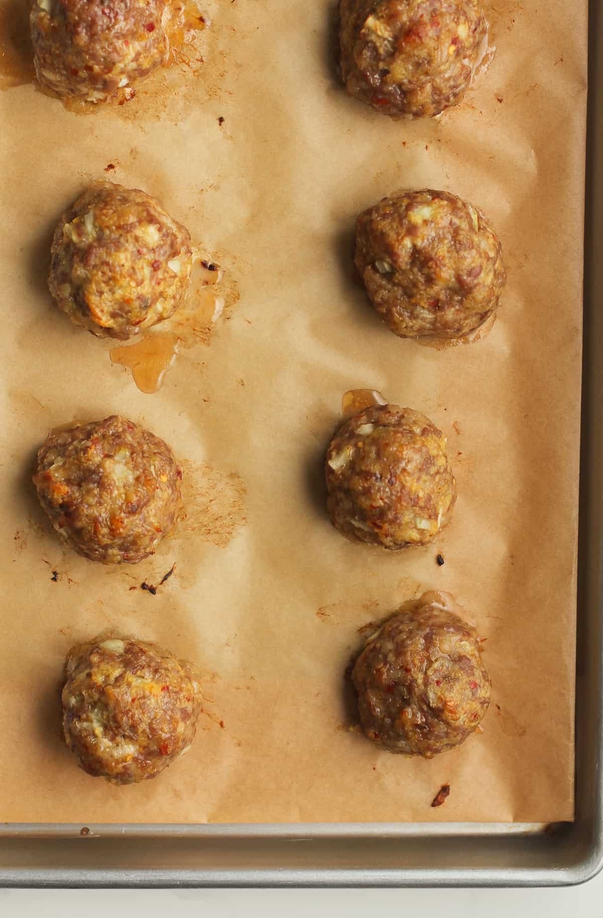 Baked sausage meatballs on a tray.