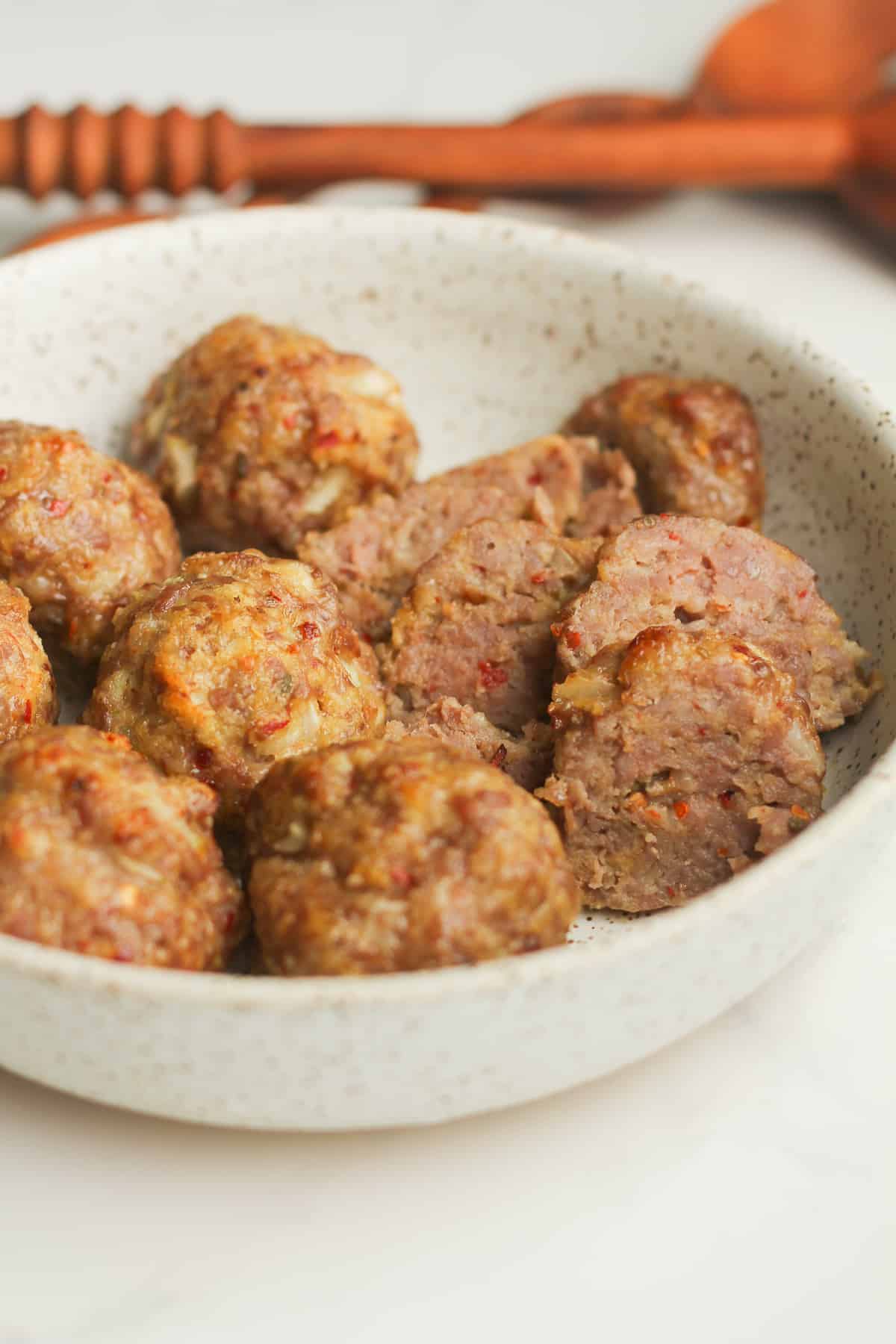 Side shot of some spicy sausage meatballs in a bowl.