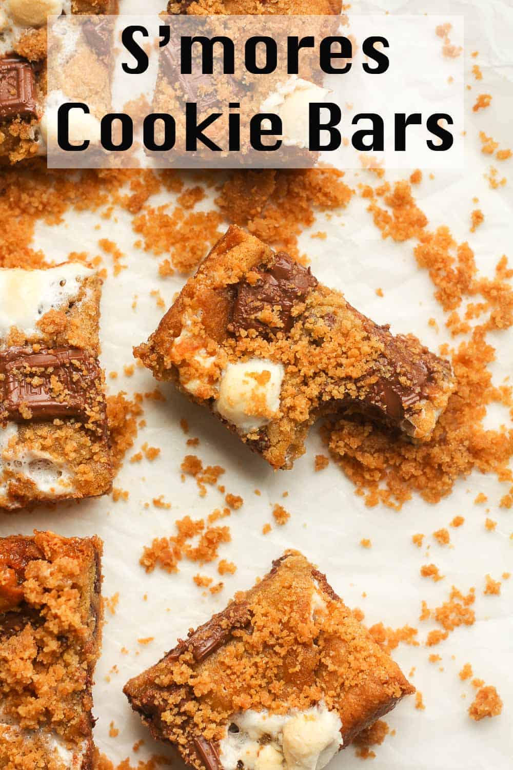 A s'mores cookie bar with a bite out with crumbs.
