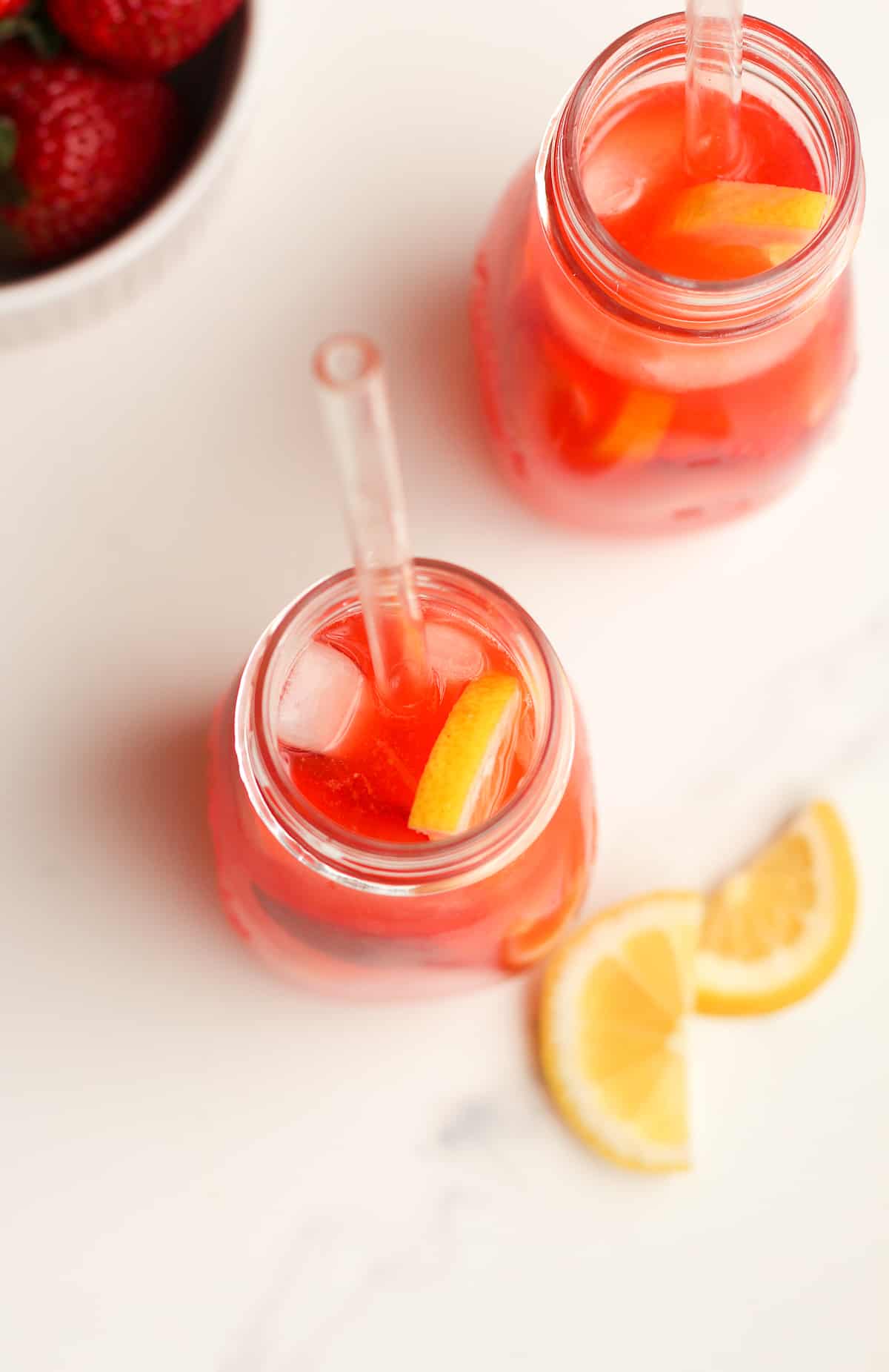 Overhead shot of two jars os strawberry lemonades with vodka.