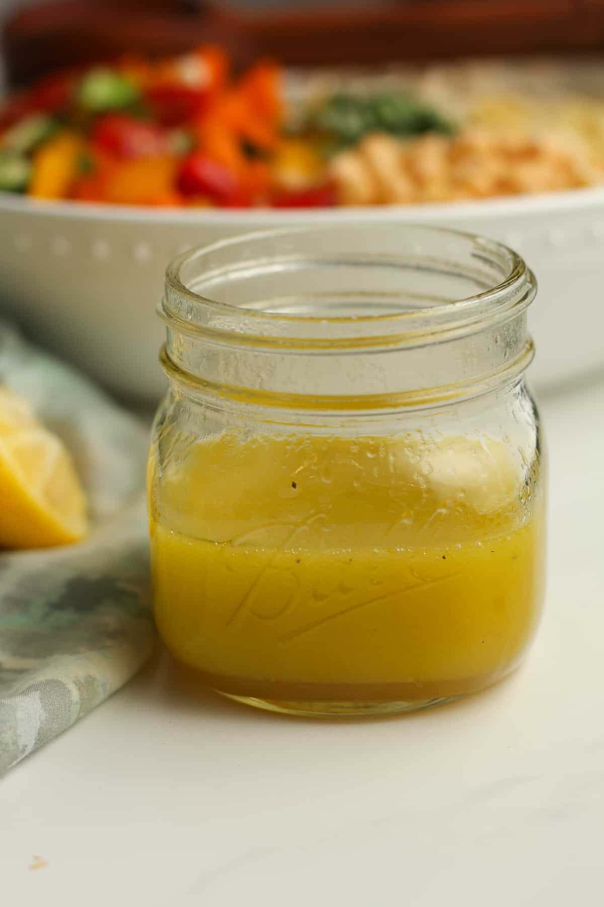 Side shot of a jar of lemon dressing.