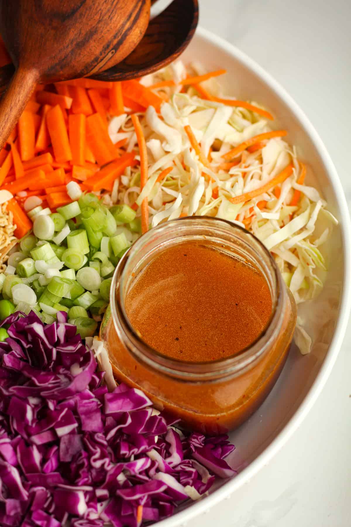 A jar of the dressing in the bowl of salad.