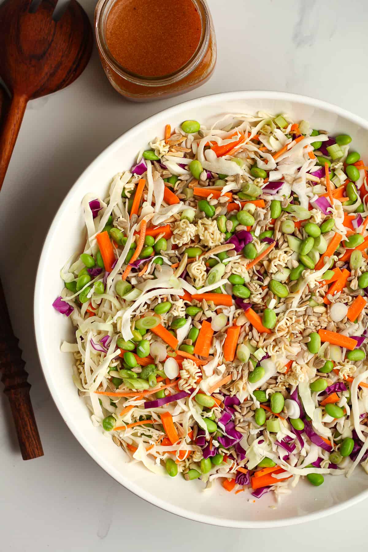 A bowl of the salad and jar of dressing beside it.