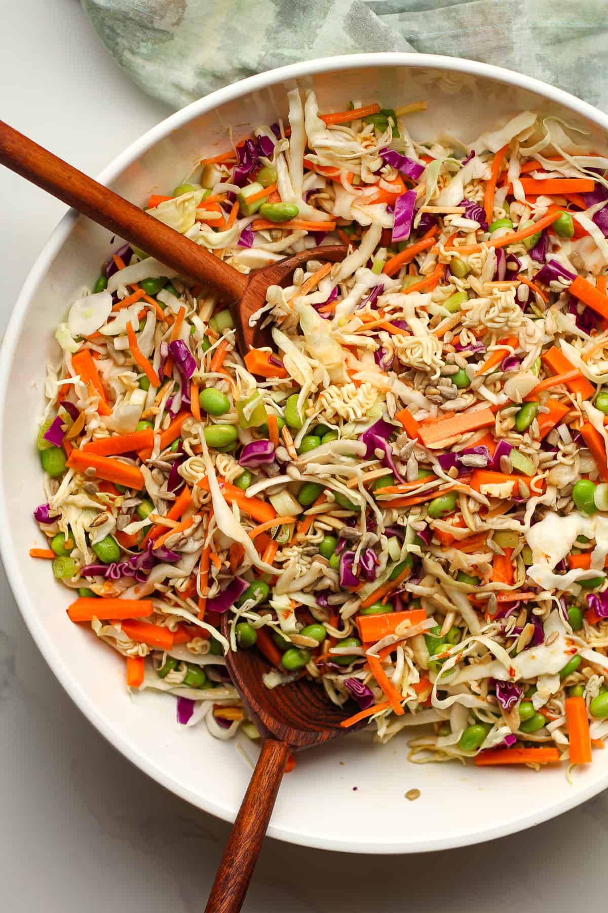 A bowl of cabbage salad with wooden spoons.