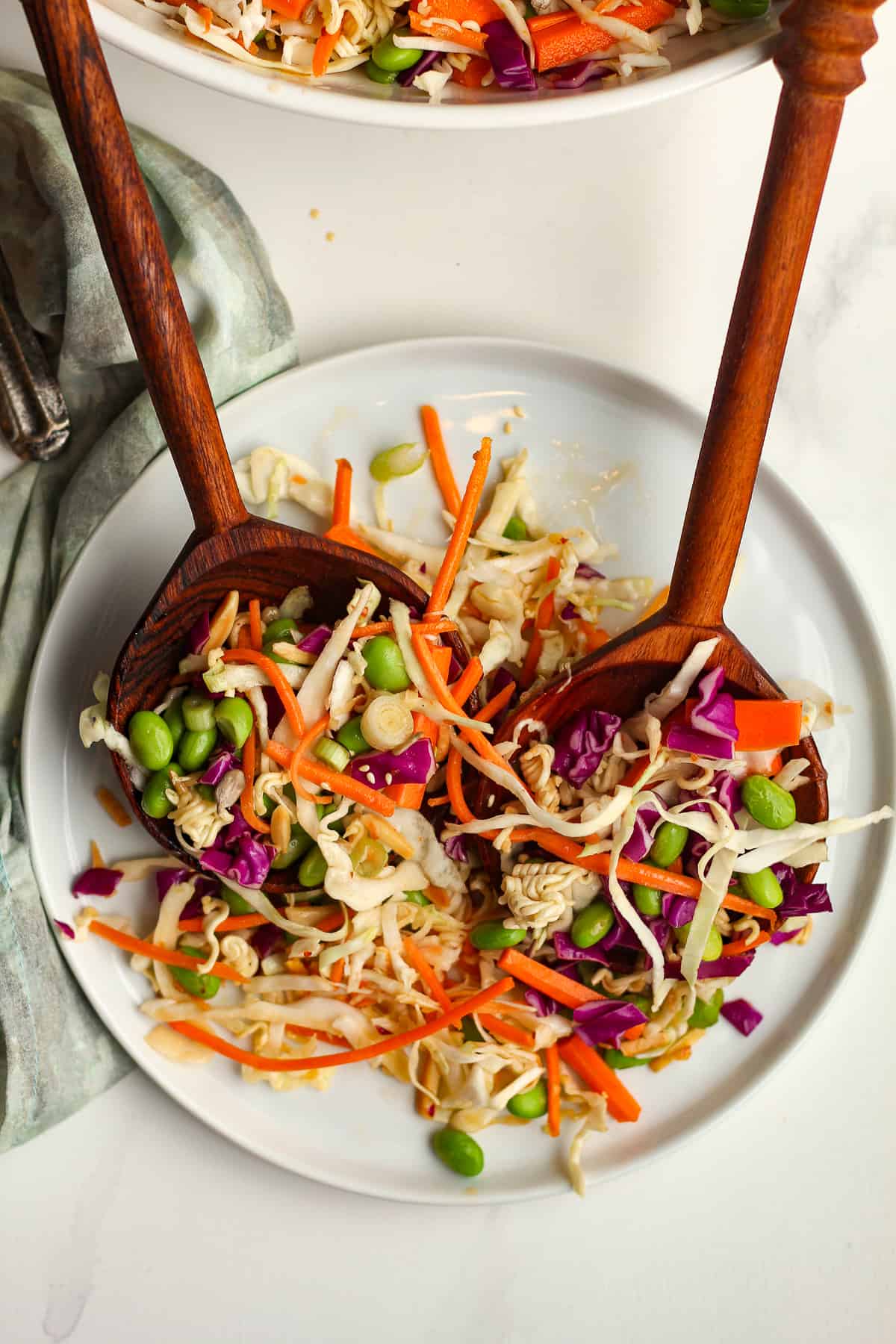 Two wooden spoons serving some cabbage salad.