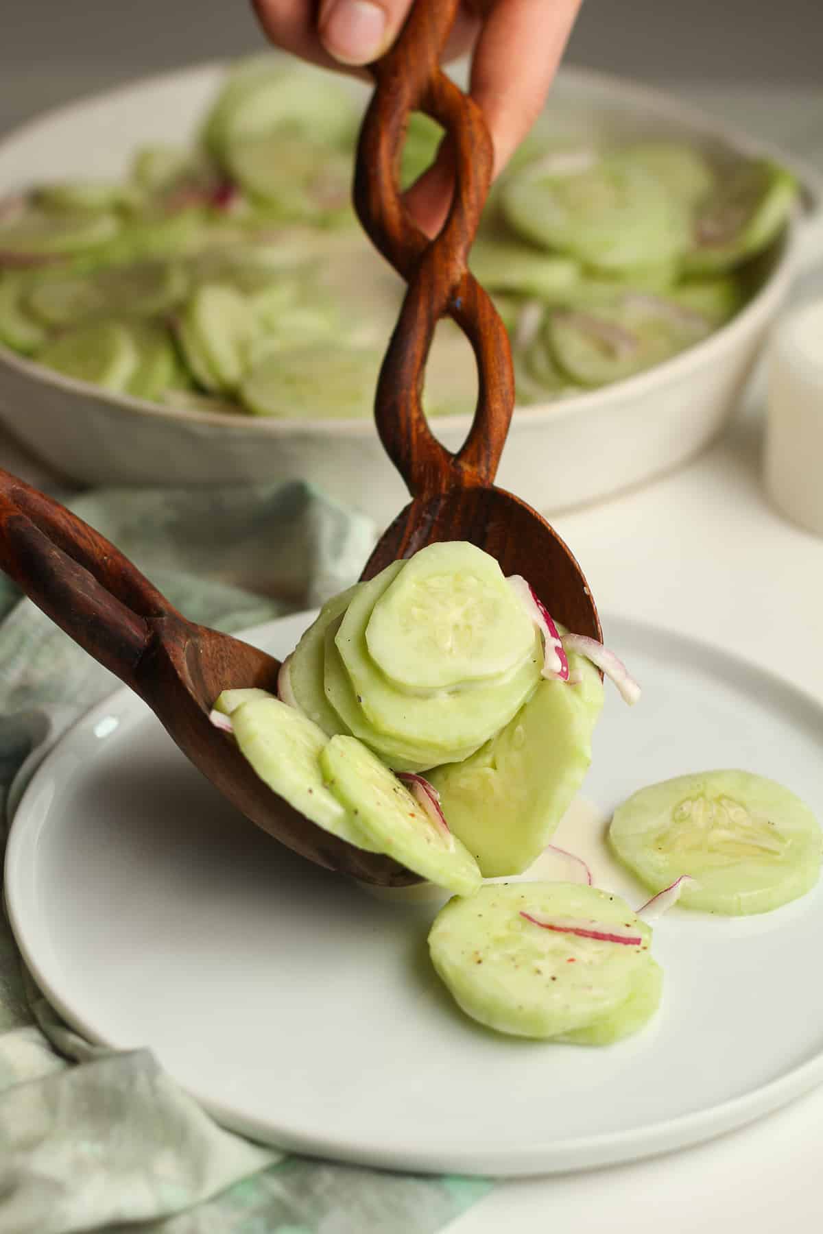 Wooden spoons serving a helping of cucumber salad.