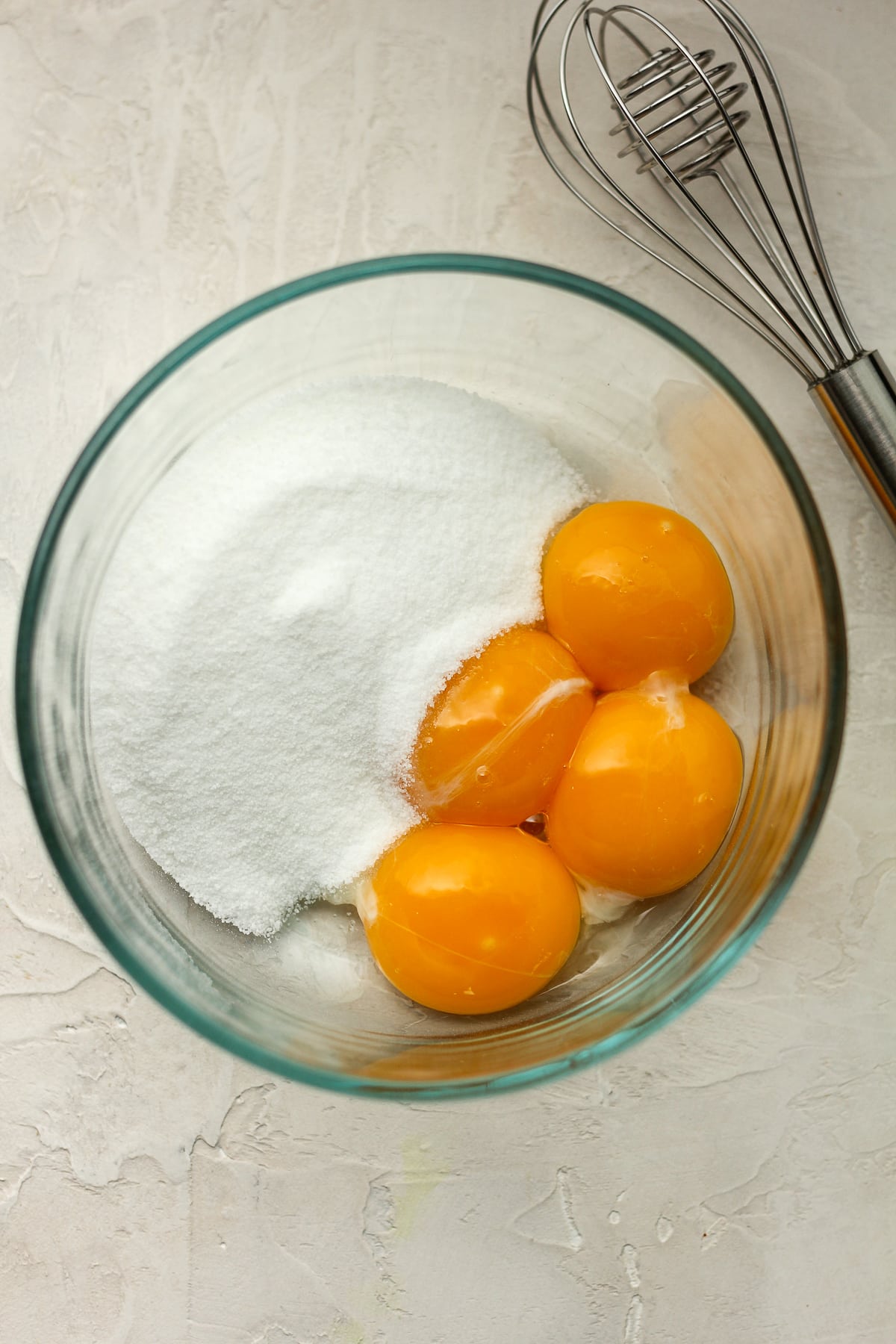 A bowl with four egg yolks and sugar.