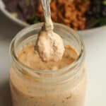 A jar of chipotle ranch with a teaspoon over top.