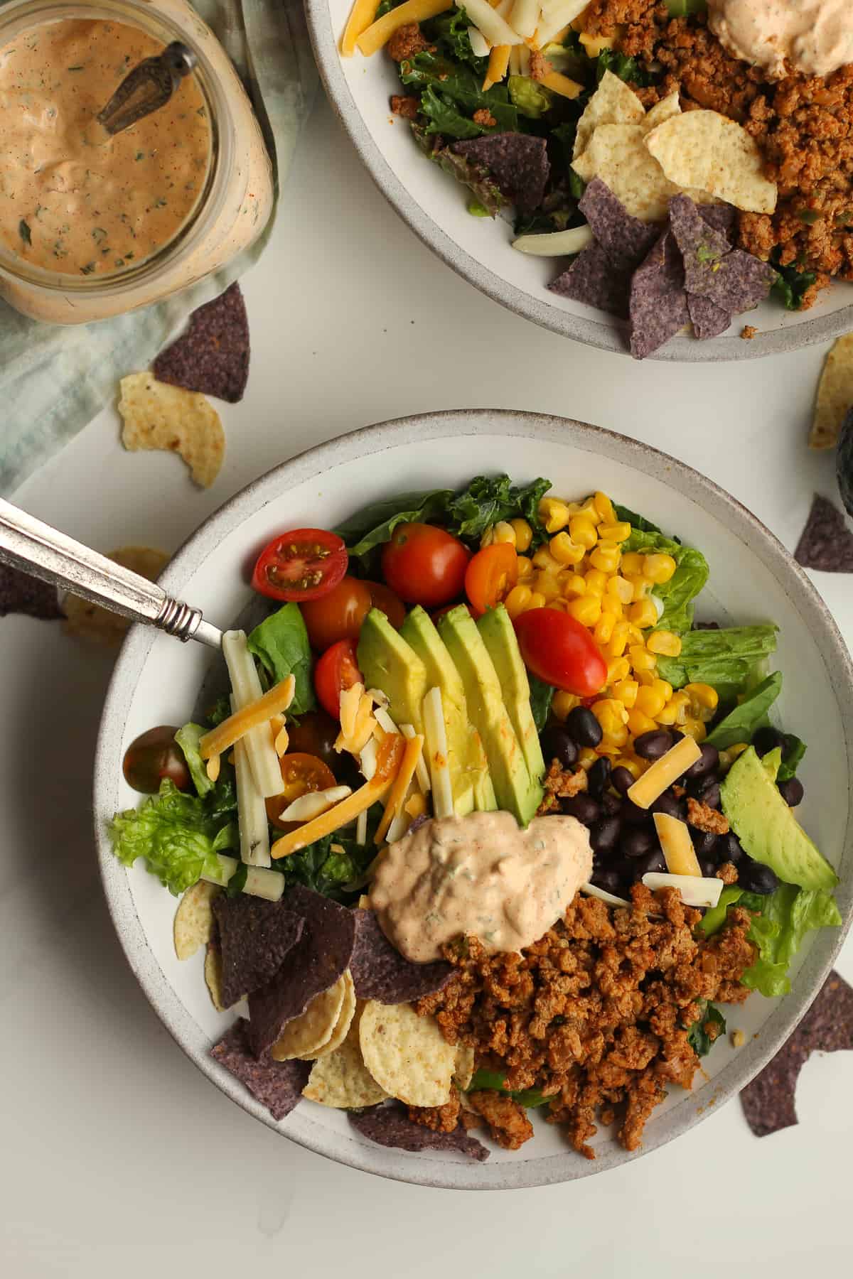 Overhead shot of taco salad with a jar of dressing.