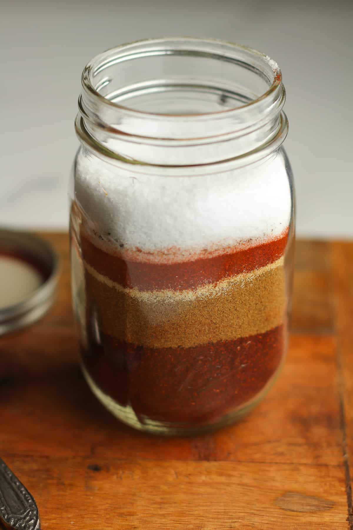 A side view of a jar of the layered homemade taco seasoning.
