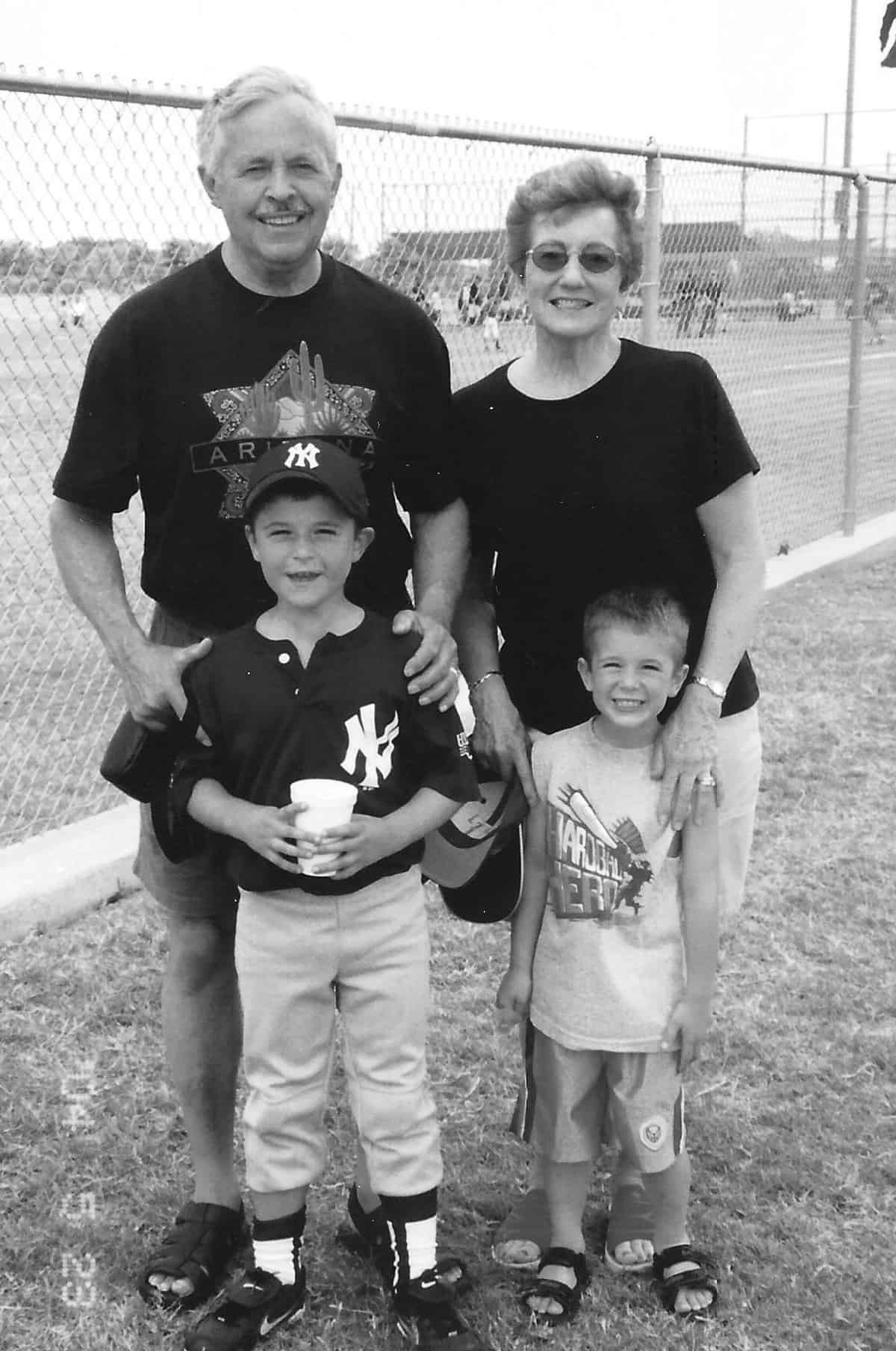 My parents at a baseball game, posed with our boys.