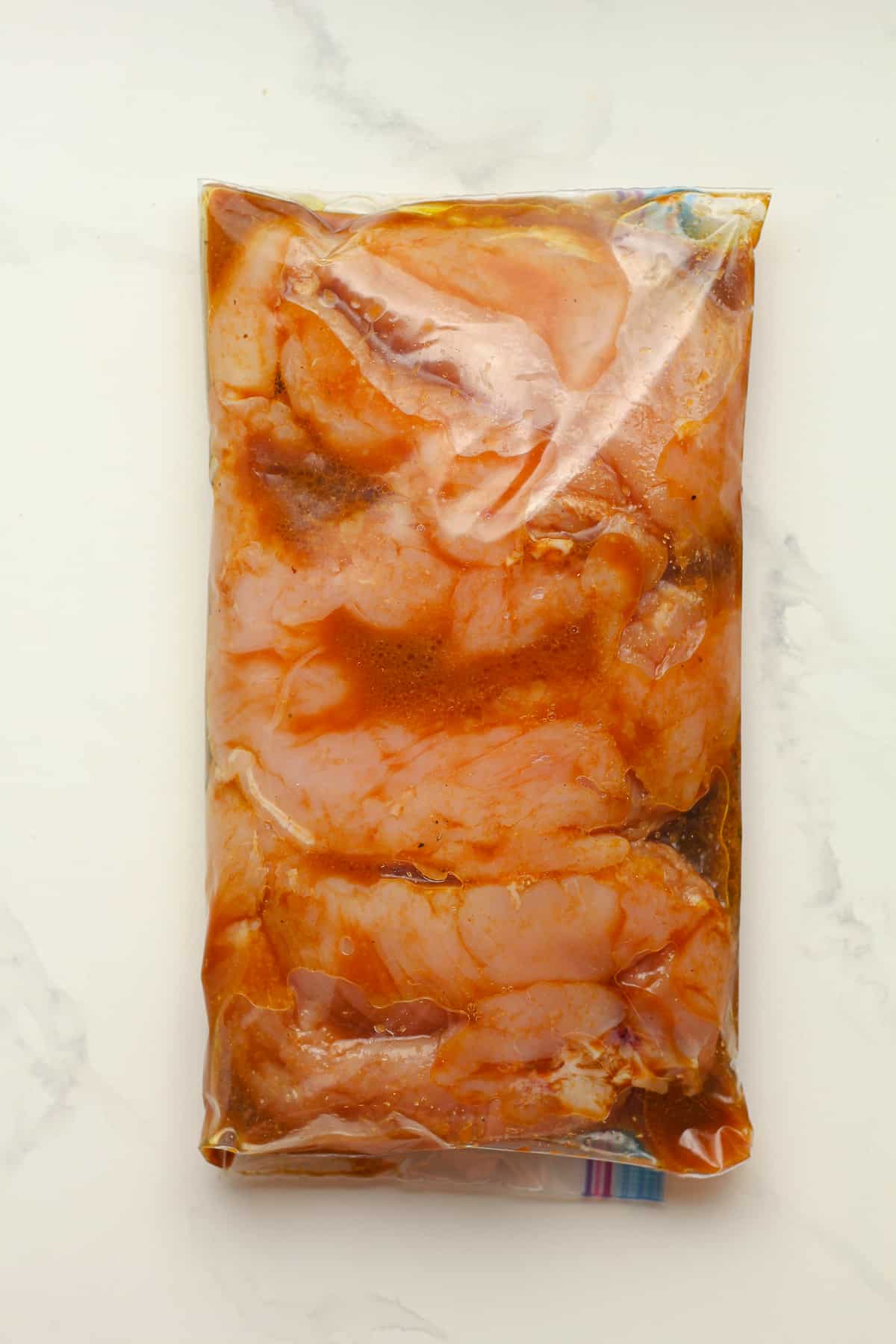 A bag of the chicken breasts in the marinade.