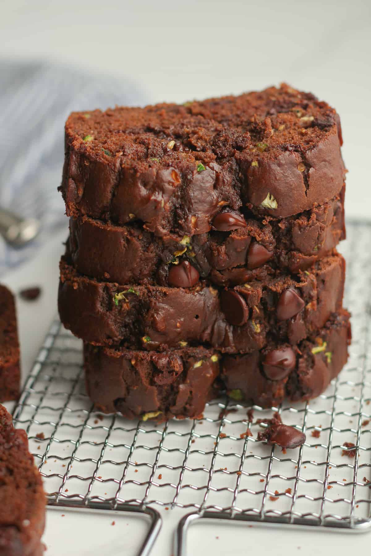 A stack of chocolate zucchini bread on a wire rack.