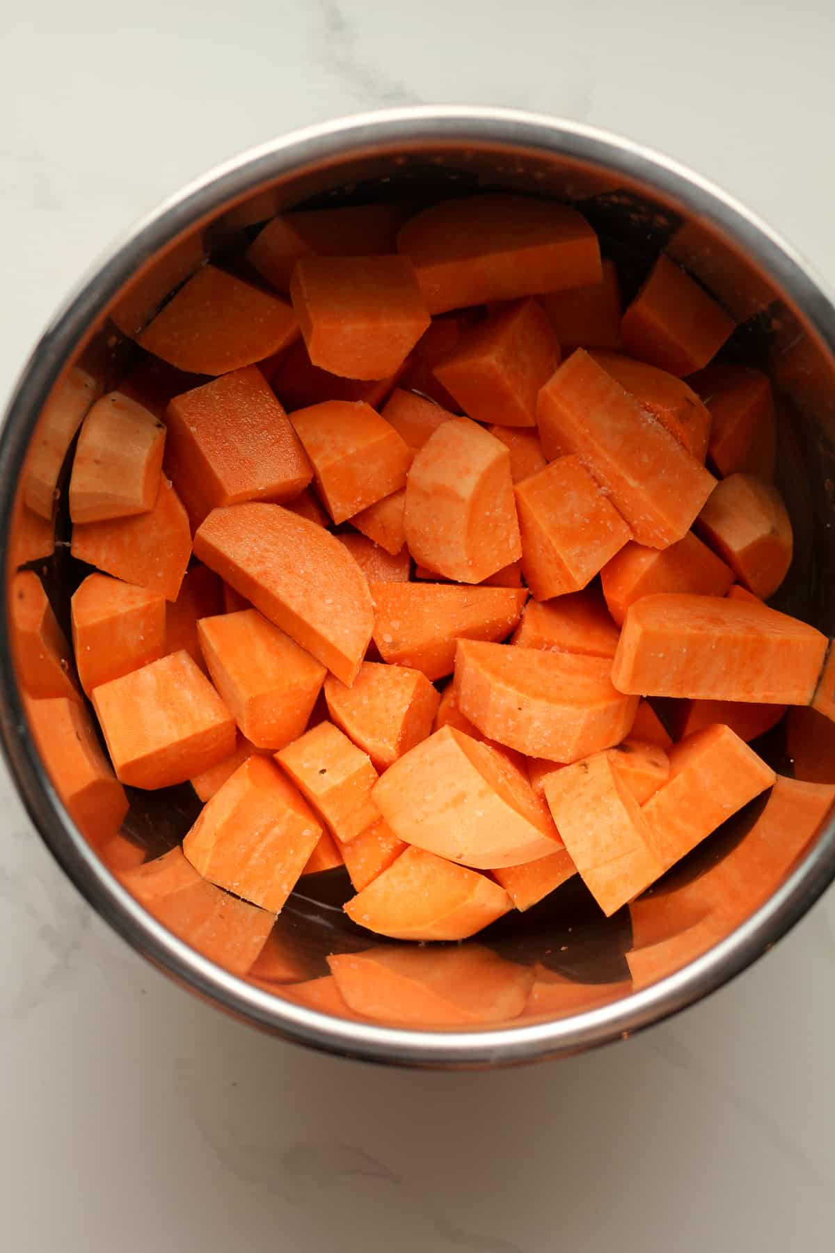 An instant pot with the chopped sweet potatoes.