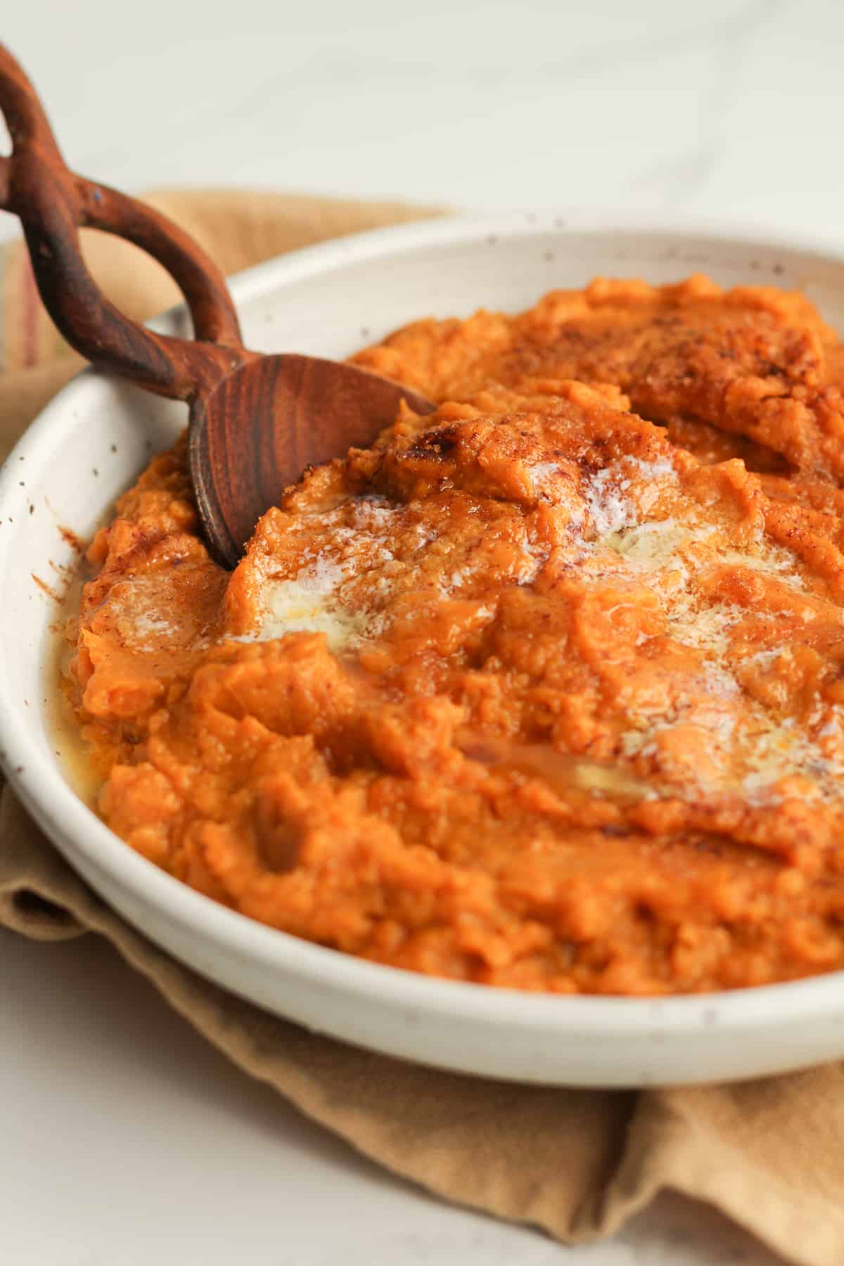 Side shot of a bowl of mashed sweet potatoes.